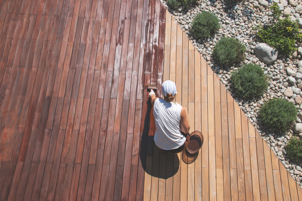 A woman finishes her deck seal in an arial photo.
