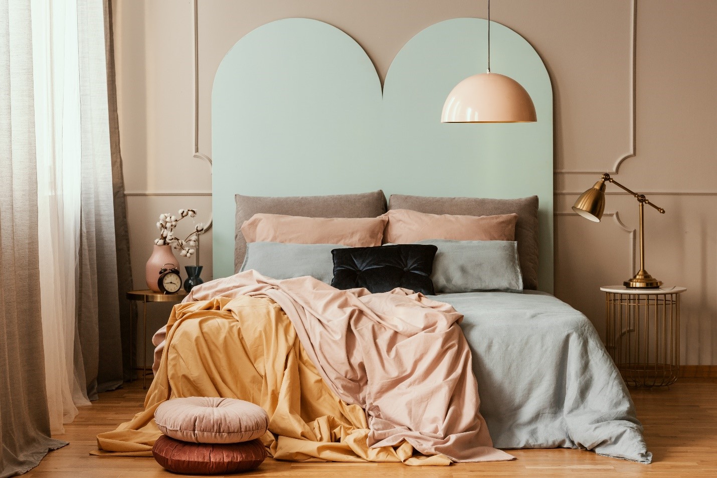 A bedroom with a decorated headboard and colorful sheets.