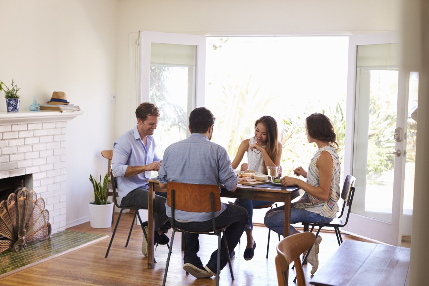 Friends laughing and sharing a meal in a space together.