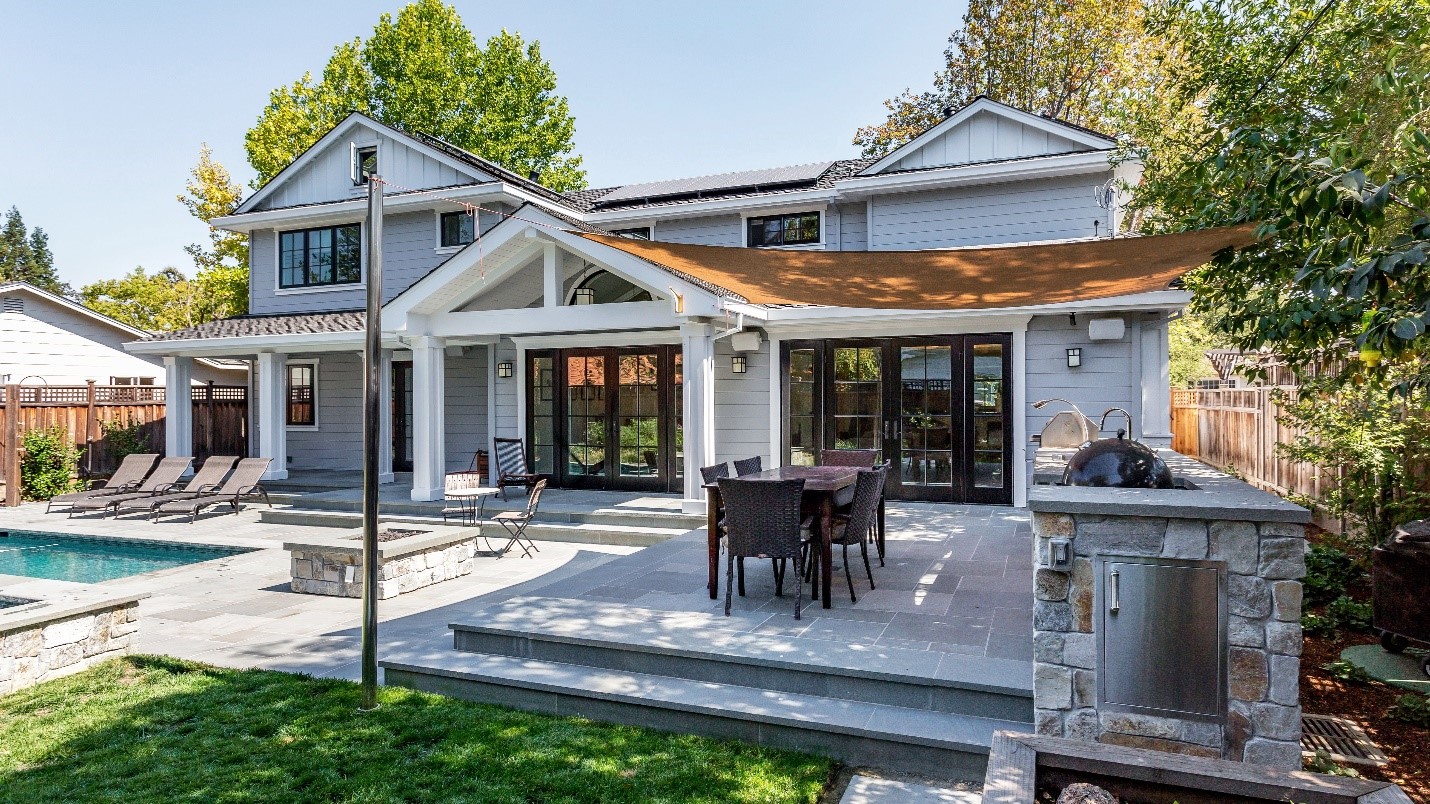 A curated backyard with a stone patio and shaded dining area.