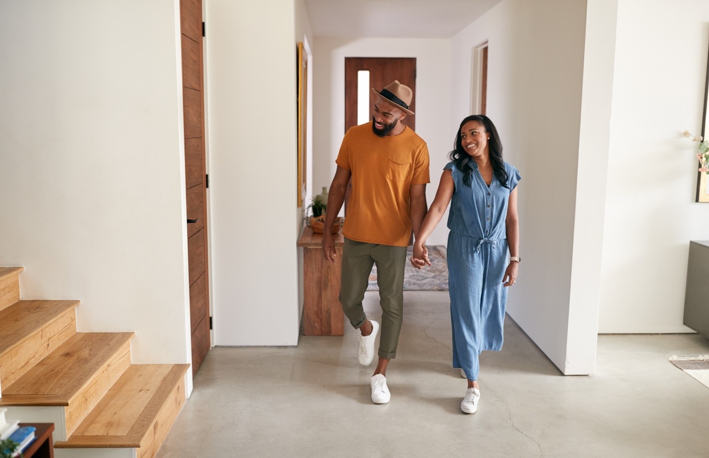 A young black couple happily looking around their new home.