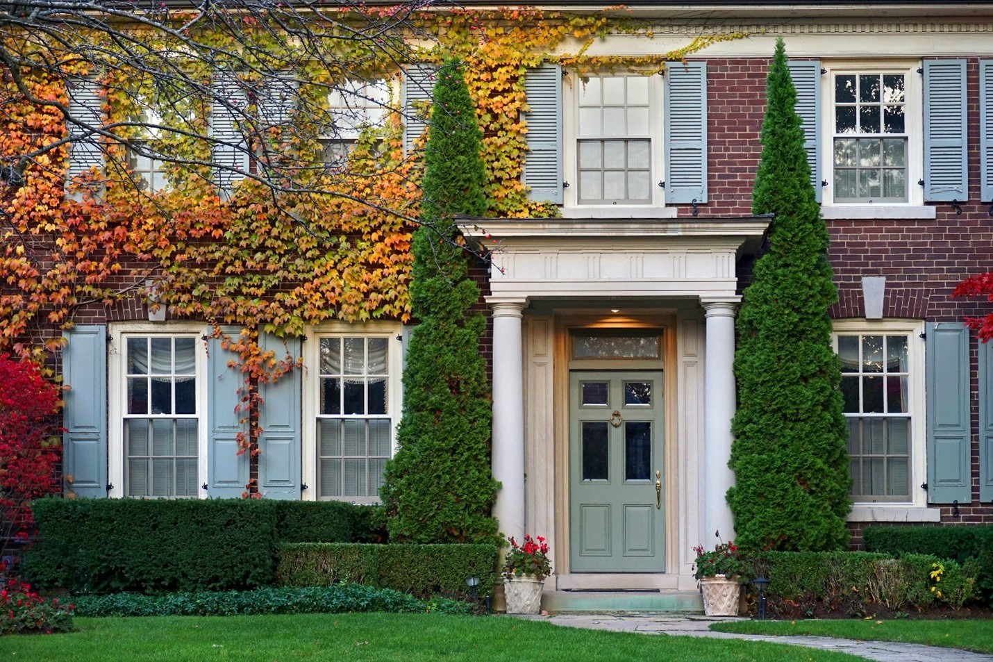 A home with climbing foliage, changing colors in the autumn weather.