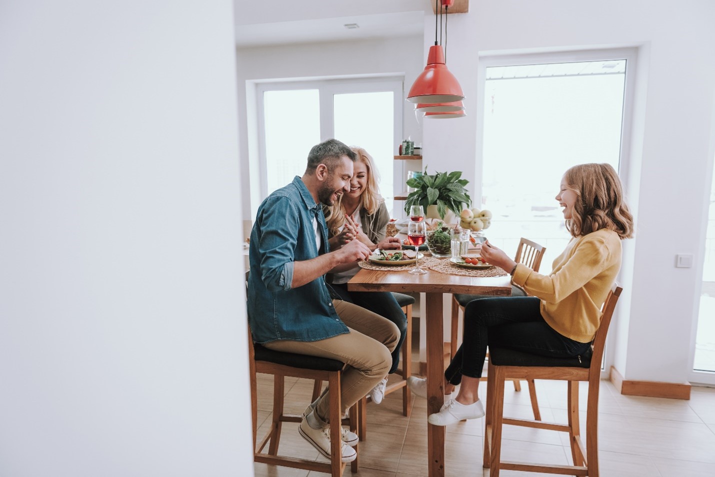 A family giggling as they share a meal together.